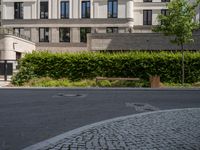 a bench is sitting in the middle of a street with buildings and trees around it