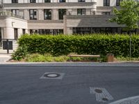 a bench is sitting in the middle of a street with buildings and trees around it