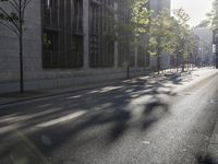 a long road next to some very tall buildings in the sun with a light at one end