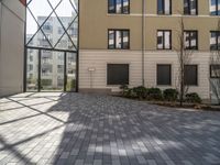 an empty courtyard is pictured in a building with lots of windows and a door on the side