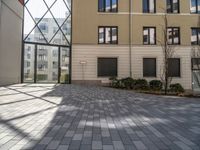 an empty courtyard is pictured in a building with lots of windows and a door on the side