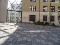 an empty courtyard is pictured in a building with lots of windows and a door on the side