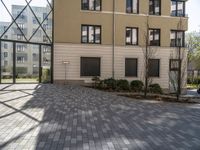 an empty courtyard is pictured in a building with lots of windows and a door on the side