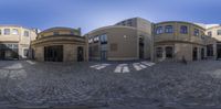 this is an upside down view of a building across from it on the corner of a cobbled sidewalk