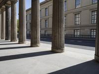 a row of large columns sitting on the side of a street between two tall buildings