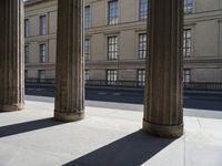 a row of large columns sitting on the side of a street between two tall buildings