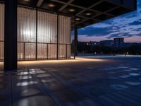 a windowed area with large glass walls, lights, and dark concrete flooring