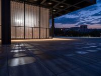 a windowed area with large glass walls, lights, and dark concrete flooring