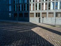 a building with several windows on the side of it and an empty street corner on the ground