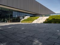 the outside of a building and stairs with a bench with steps up to it on the ground