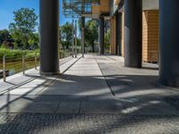 a road through which is a large modern building with an awning over it's entrance