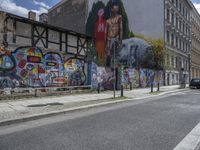 the street in front of the graffiti covered building is empty and empty, but has two rows