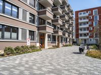 an apartment complex with a small walkway and brick patio area leading into the building facade