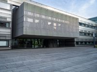 a building with an outdoor area next to it and grass growing at the side of it