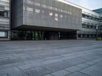 a building with an outdoor area next to it and grass growing at the side of it