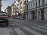 a red truck is parked on the side of a street next to some buildings and buildings