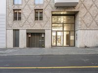 the entrance to an office building on a street next to bricked buildings with doors and windows