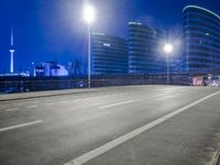 city streets at night with lights shining over the top of buildings and a long highway