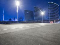 city streets at night with lights shining over the top of buildings and a long highway