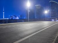 city streets at night with lights shining over the top of buildings and a long highway