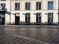 a couple of tables in the middle of a road next to a building with windows