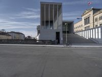 a bicycle is parked outside of the building at the entrance to the building, next to the bike path and steps