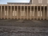 the shadow of poles cast by the sun on the outside wall of the building, casting light onto the floor