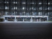 an empty bus station lit up in a city night time light, with no one in the front