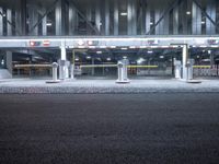 an empty bus station lit up in a city night time light, with no one in the front