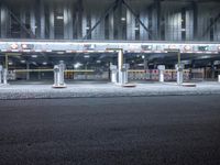 an empty bus station lit up in a city night time light, with no one in the front