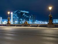 this picture shows a night time view of a city street and lights on the bridge