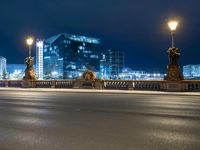 this picture shows a night time view of a city street and lights on the bridge