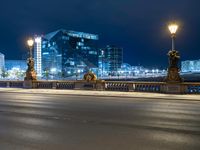 this picture shows a night time view of a city street and lights on the bridge