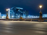 this picture shows a night time view of a city street and lights on the bridge