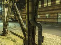 a very tall pipe that is near a building by the street light at night time