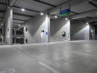 parking garage floor with silver tiles and circular holes at the entrance to the building and signs