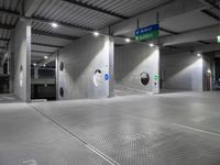 parking garage floor with silver tiles and circular holes at the entrance to the building and signs