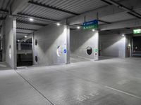 parking garage floor with silver tiles and circular holes at the entrance to the building and signs