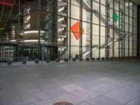 a very big square with some stairs and windows at night time with a fire hydrant sitting in front of it