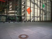 a very big square with some stairs and windows at night time with a fire hydrant sitting in front of it