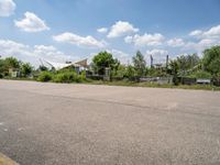 the empty parking lot in front of the small residential house and lots of greenery