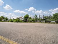 the empty parking lot in front of the small residential house and lots of greenery