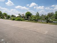 the empty parking lot in front of the small residential house and lots of greenery