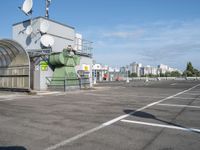 a bus stop is in the middle of a parking lot, where there are several satellite antennas on the side