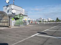 a bus stop is in the middle of a parking lot, where there are several satellite antennas on the side