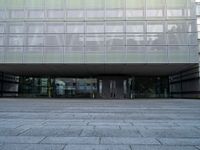 a big building with many windows on the outside of it, and stone flooring