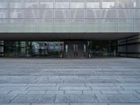 a big building with many windows on the outside of it, and stone flooring