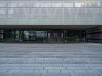 a big building with many windows on the outside of it, and stone flooring