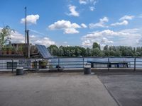 the benches are next to a lake on a sunny day and look out at clouds