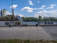 the benches are next to a lake on a sunny day and look out at clouds